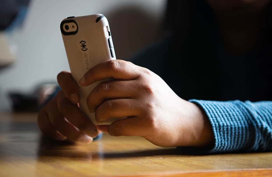 Zoom in on a child's hands holding a mobile phone